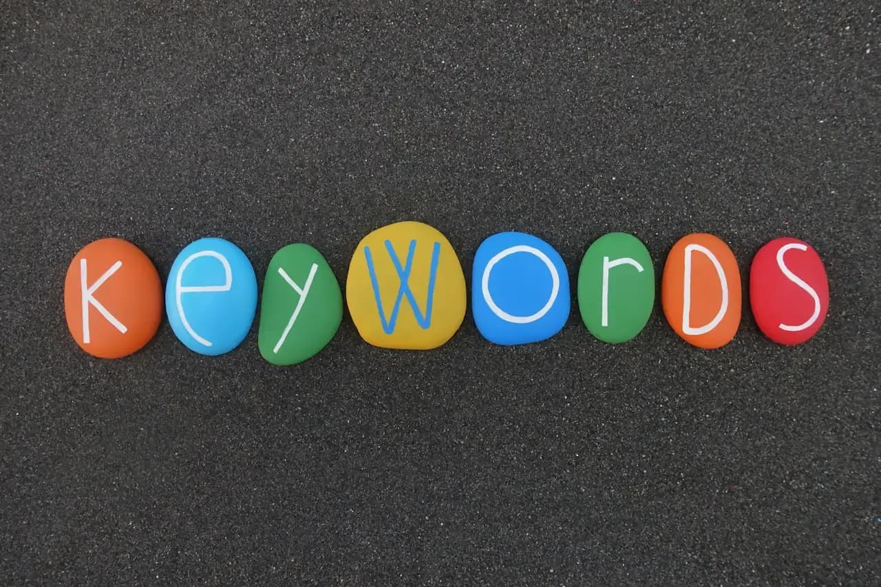 המילה Keywords מורכבת מאבנים צבעוניות על חול וולקני שחור