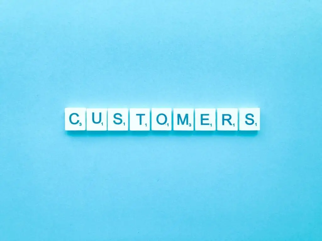 אריחי משחק שמרכיבים את המילה Customers על רקע תכלת